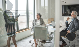 A picture containing 2_women_discussing_business_at_table_laptop